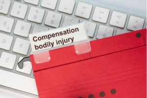 Keyboard and folder with tab reading Compensation bodily injury