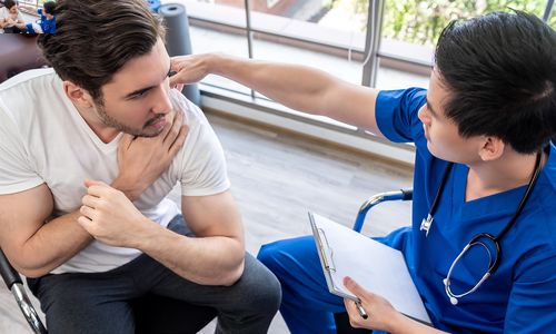 A doctor treating a man with a workplace injury