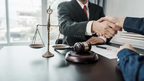 A workers' compensation lawyer shaking hands with a client.